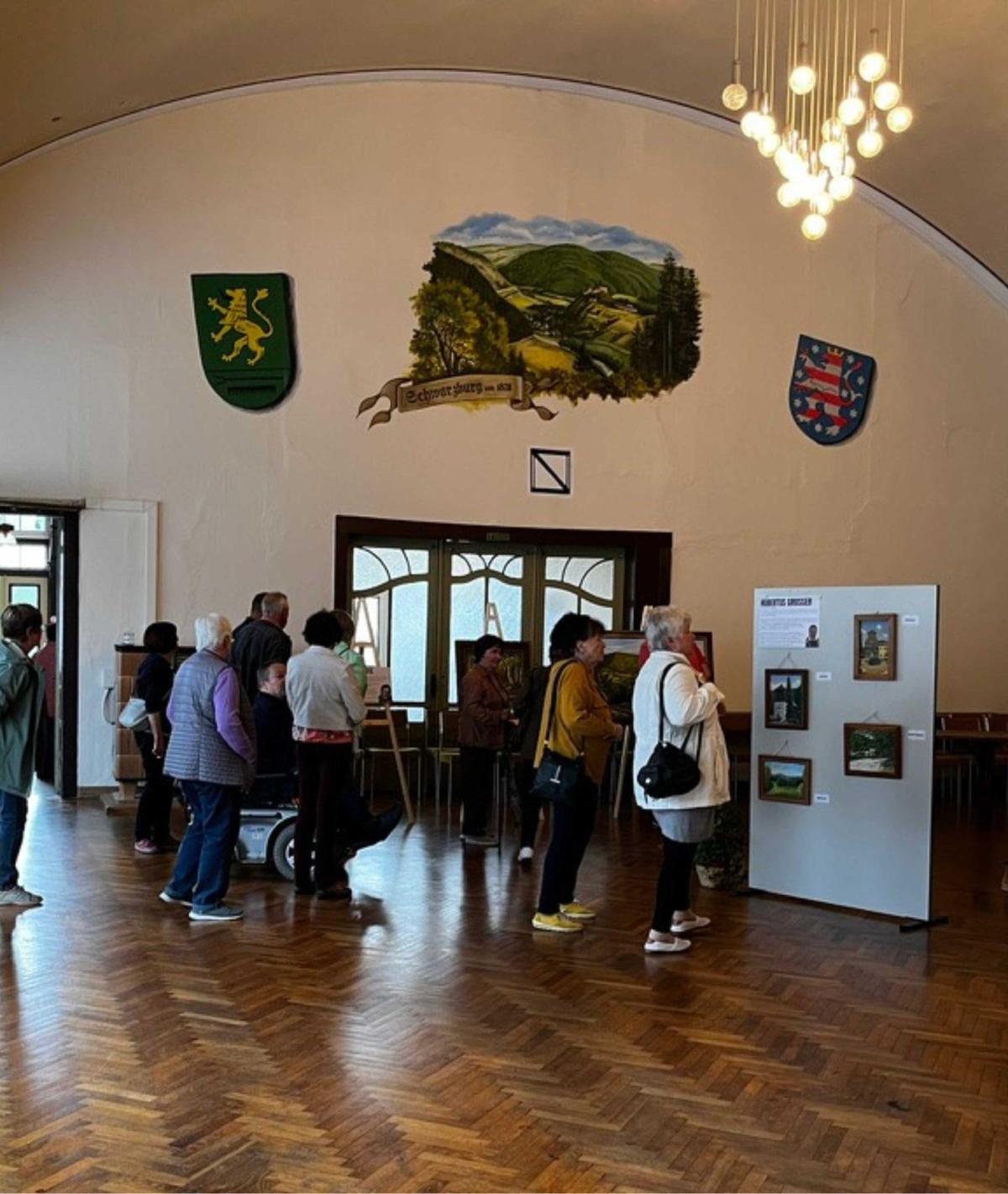 Besucherinnen und Besucher bei einer Ausstellung im Festsaal